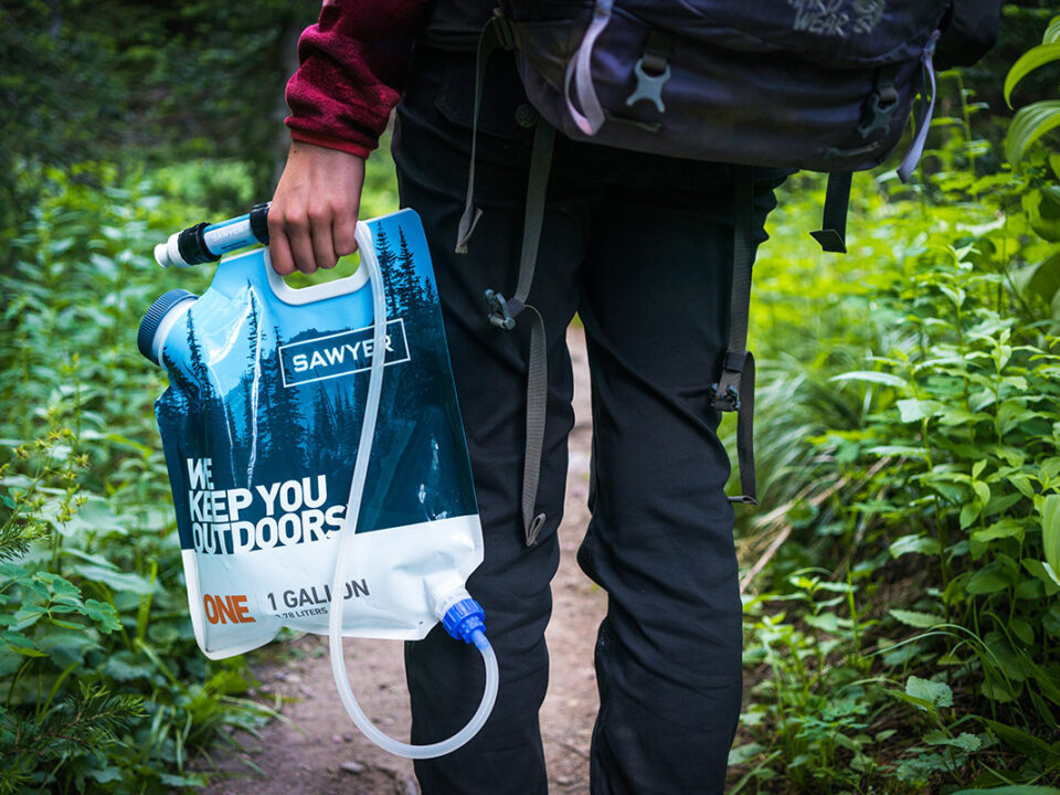 Person easily carrying a Sawyer water filter and bag