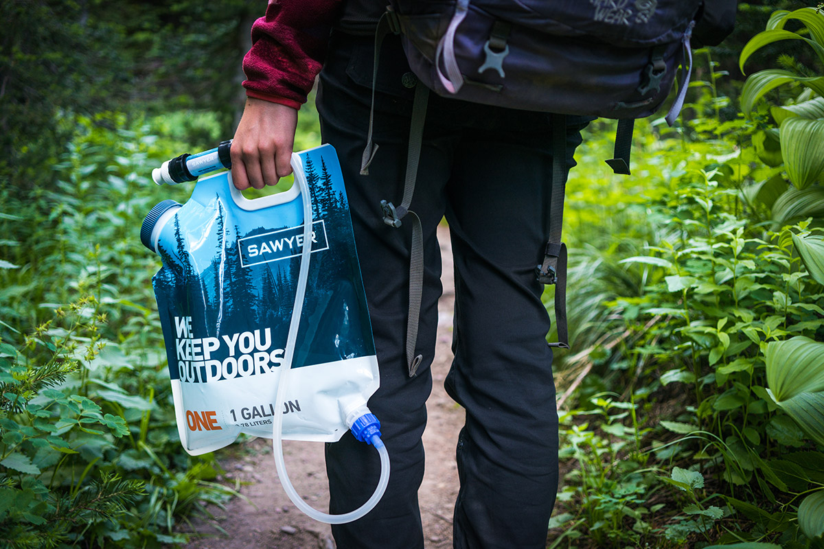 Person easily carrying a Sawyer water filter and bag